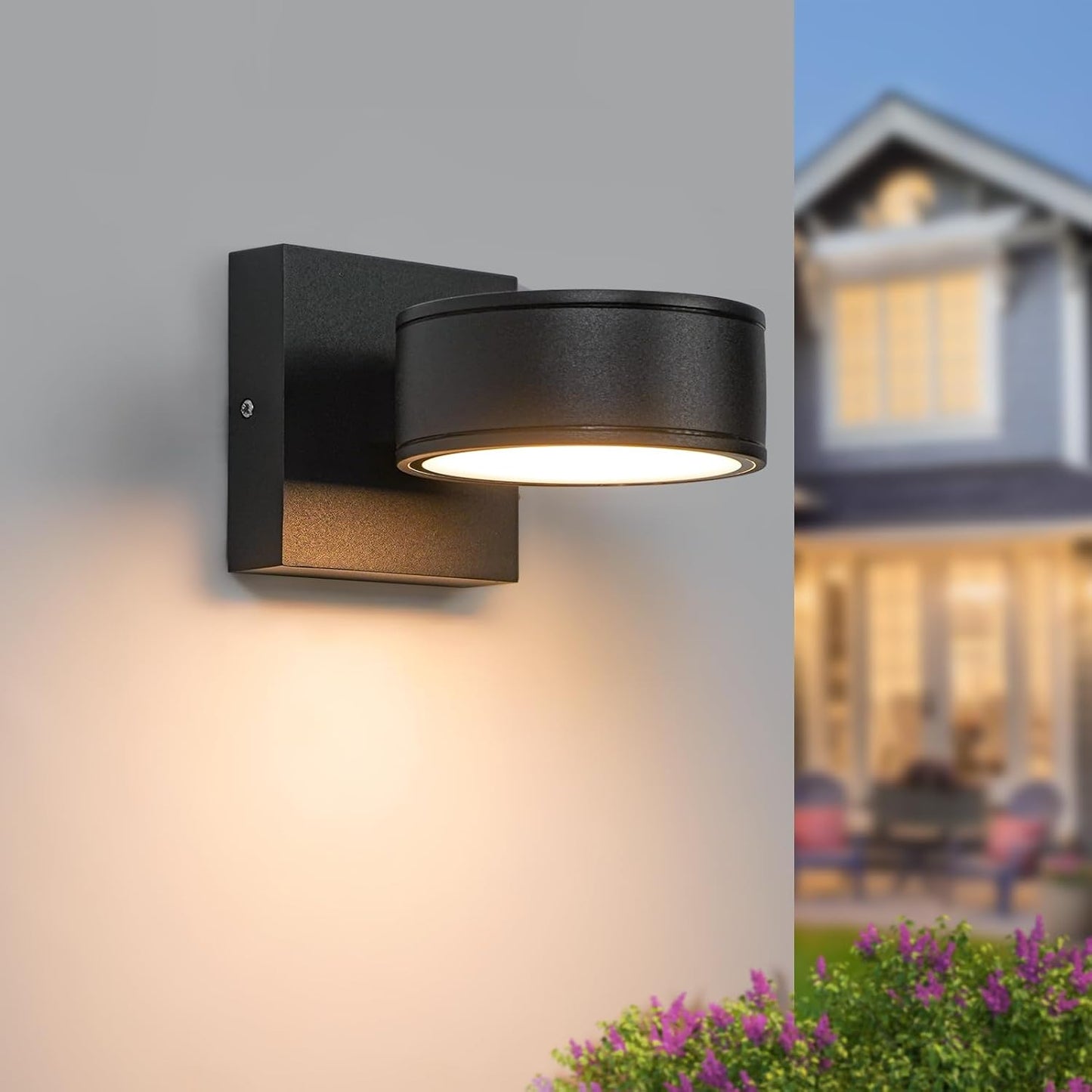 Black outdoor wall light fixture on a gray background with a blurred house in the background.