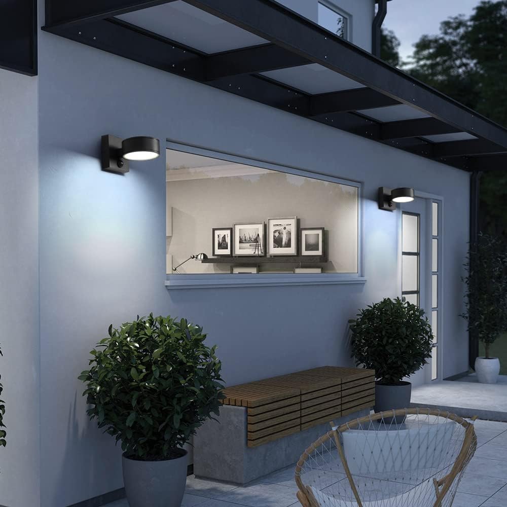 Modern outdoor setting with a wall mirror, bench, and potted plants on a patio.