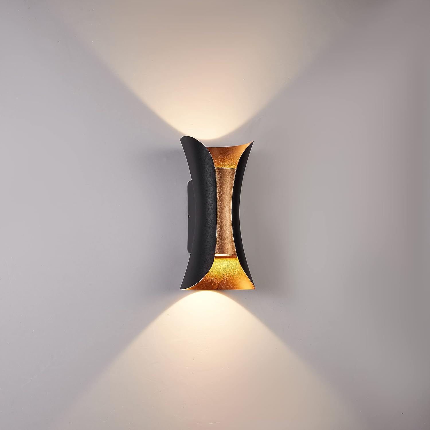 Modern wall lamp with black and gold design on a gray wall