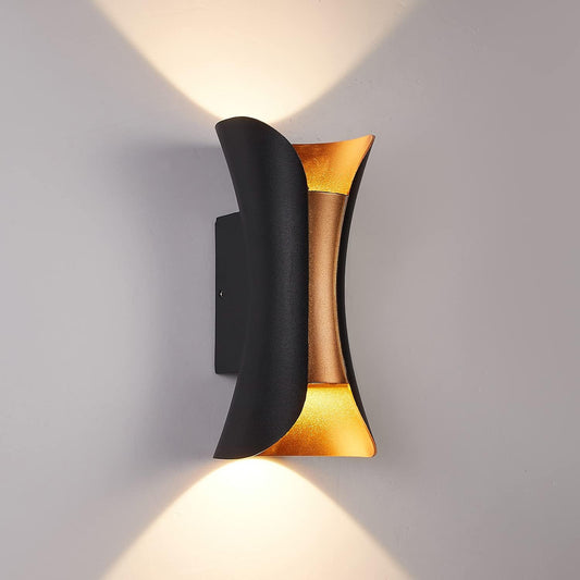Modern wall light fixture with black and gold design on a gray background