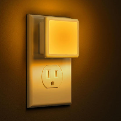 Night light attached to a wall outlet with a warm glow