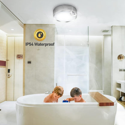 Two children playing in a white bathtub with a 'IP54 Waterproof' sign in the background.