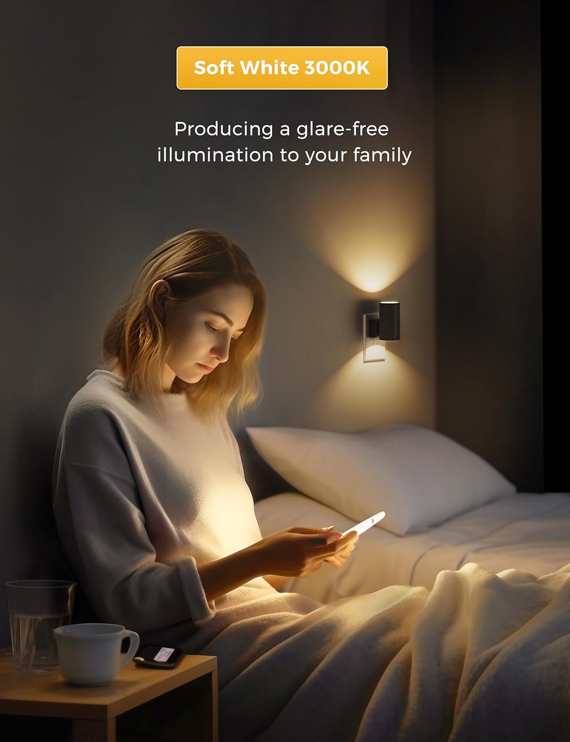Woman sitting on a bed using a smartphone with soft white light illuminating the room.